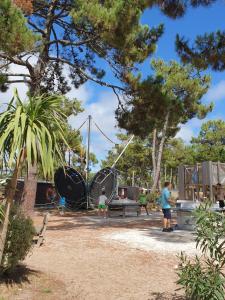 un grupo de personas jugando en un patio de recreo en Mobil Home 6 personnes Camping 5 étoiles, en Vendays-Montalivet