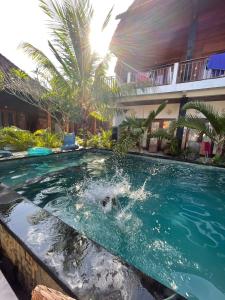 a swimming pool with a dolphin in the water at Swara Homestay 2 in Nusa Lembongan