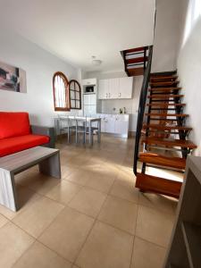 sala de estar con sofá rojo y cocina en Parquemar, en Playa del Inglés