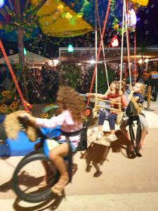 un grupo de niños montados en un carrusel en un carnaval en Mobil Home 6 personnes Camping 5 étoiles, en Vendays-Montalivet