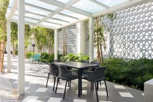 a table and chairs on a patio with a pergola at UNA Serviced Apartment, Sunway Velocity Kuala Lumpur in Kuala Lumpur