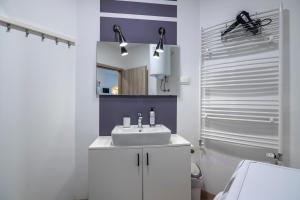a white bathroom with a sink and a mirror at Nika & Erik in Kranjska Gora