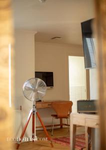 a room with a fan and a desk with a television at Axel Guldsmeden in Copenhagen