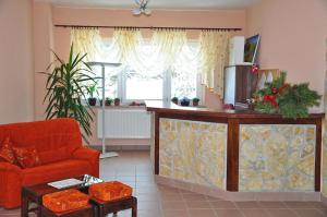 a living room with a red chair and a counter at Penzión Antares in Zuberec