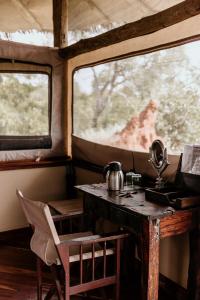 a table and chair in a room with a window at Tarangire Treetops in Kwa Kuchinia +36 photos