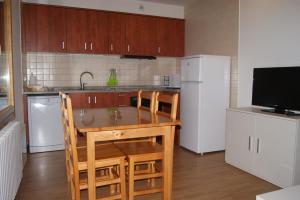 a kitchen with a table and chairs and a refrigerator at Apartamentos Borruscall in Pas de la Casa