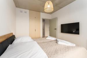 ein Schlafzimmer mit zwei Betten und einem Flachbildfernseher in der Unterkunft Optima na Wyspie Solnej z parkingiem in Kołobrzeg