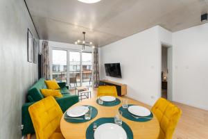 ein Wohnzimmer mit einem Tisch und einer grünen Couch in der Unterkunft Optima na Wyspie Solnej z parkingiem in Kołobrzeg