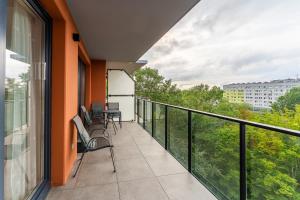 ein Balkon mit Stühlen und Blick auf ein Gebäude in der Unterkunft Optima na Wyspie Solnej z parkingiem in Kołobrzeg