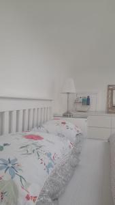 Un dormitorio con una cama con una manta floral. en Amberley, en Gorey