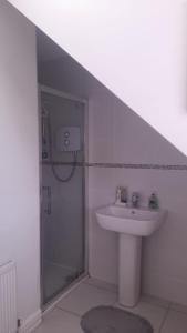 a white bathroom with a sink and a shower at Amberley in Gorey