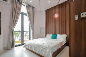 a bedroom with a large bed and a large window at Lâm Phong Hotel in Tây Ninh