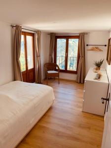 Schlafzimmer mit einem Bett, einem Schreibtisch und Fenstern in der Unterkunft Casa Mille Sassi in Lionza