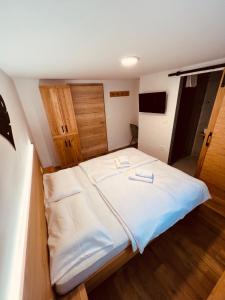 ein Schlafzimmer mit einem großen Bett mit weißer Bettwäsche in der Unterkunft PJagodic Hotel Cerklje - 5min to Airport in Cerklje na Gorenjskem