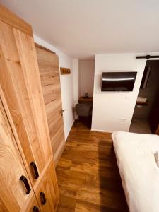 een kamer met een houten deur en een bed erin bij PJagodic Hotel Cerklje - 5min to Airport in Cerklje na Gorenjskem