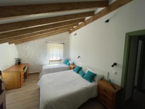 a bedroom with two beds in a room with wooden ceilings at Casa Rural la Marina in Las Rozas de Valdearroyo