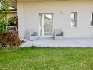 2 sillas sentadas en un patio frente a una casa en B&B Controvento Soiano, en Soiano del Lago