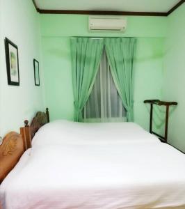 een slaapkamer met een groot wit bed en een raam bij 1511 Guest House in Melaka