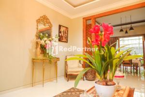 a room with a mirror and a table with flowers at Rumah CIA Taman Siswa near Malioboro Yogyakarta Mitra RedDoorz in Timuran