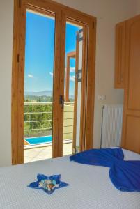 a bedroom with a bed with a view of a balcony at Sea View Three Bedroom Villa Giorgios in Gavalochori
