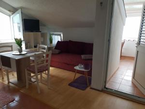 un salon avec un canapé rouge et une table dans l'établissement Apartments by the sea Mandre, Pag - 6386, à Kolan