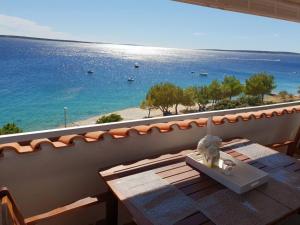 une table sur un balcon avec vue sur l'océan dans l'établissement Apartments by the sea Mandre, Pag - 6386, à Kolan