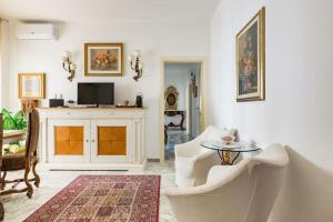 un soggiorno con 2 sedie bianche e un tavolo di B&B Casa Sabella a Lecce