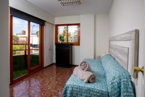 a bedroom with a blue couch with a dog on it at GANDIACENTRUM in Gandía