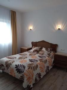 a bedroom with a bed with a colorful comforter at Apartament lângă Catedrală in Câmpulung Moldovenesc
