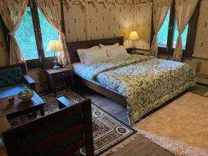 une chambre avec un lit dans une pièce avec des fenêtres dans l'établissement EVAAN RESORTS THE FOLIAGE, à Mukteswar