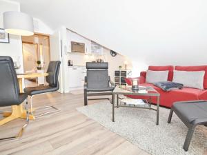 a living room with a red couch and chairs at Wohnpark Stadt Hamburg - Apt. 45 in Binz