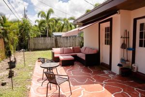 a patio with a couch and a table and chairs at Light & Cozy House in Pompano Beach - BBQ, Patio, Parking in Pompano Beach