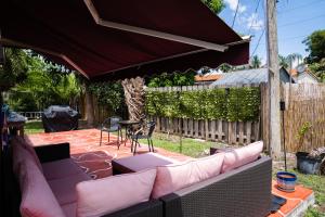 a backyard patio with a couch and a table at Light & Cozy House in Pompano Beach - BBQ, Patio, Parking in Pompano Beach