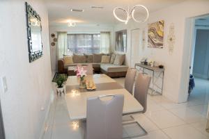 a dining room and living room with a table and chairs at Light & Cozy House in Pompano Beach - BBQ, Patio, Parking in Pompano Beach