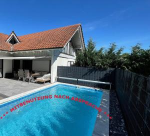 a swimming pool in front of a house at Appartement Lena in Weissach Im Tal