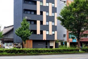 a tall black building on the side of a street at Rinn Horikawa Gojo in Kyoto