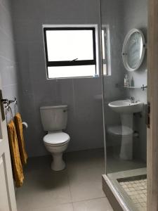 a bathroom with a toilet and a sink and a window at Margate Sunset Apartments in Margate