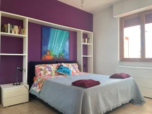 1 dormitorio con 1 cama con pared morada en Appartamento in Residence Santa Monica, en Campomarino