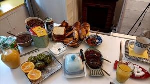 a table with a bunch of breakfast foods on it at Bienvenue in Saint-Pierre-de-Plesguen