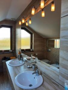 La salle de bains est pourvue de 2 lavabos et d'un grand miroir. dans l'établissement Apartmán Mikulov, à Mikulov