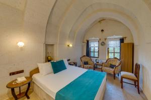1 dormitorio con 1 cama, mesa y sillas en El Puente Cave Hotel, en Ürgüp