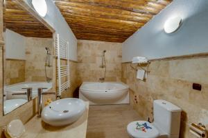 a bathroom with a tub and a toilet and a sink at El Puente Cave Hotel in Ürgüp