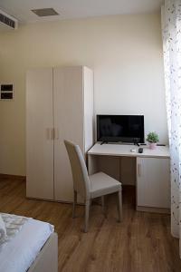 a bedroom with a desk with a chair and a computer at Treviso Rooms in Treviso