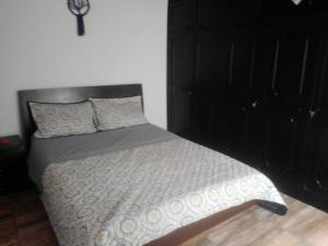 a bedroom with a bed with a black headboard at Casa acogedora en Santa Rosa de Cabal in Santa Rosa de Cabal