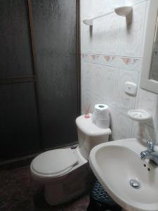 a bathroom with a white toilet and a sink at Casa acogedora en Santa Rosa de Cabal in Santa Rosa de Cabal