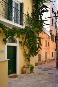 a building with a green door on a street at CASA VERDE in Corfu