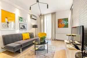 ein Wohnzimmer mit einem Sofa und einem TV in der Unterkunft Venus Apartments - King Street II - Balcony in Budapest