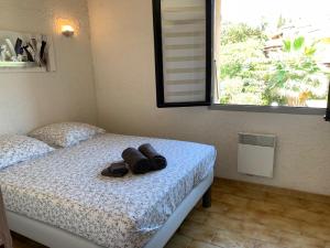 - une chambre dotée d'un lit avec une paire de chaussures dans l'établissement Résidence du Parc de la Liscia, à Calcatoggio