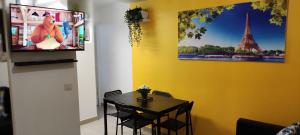 a dining room with a table and a tv on a wall at Promotion du jour - L'Olivier - in Deuil-la-Barre +15 photos