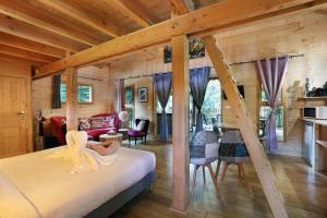 a bedroom with a bed and a living room at Les Lodges de Babylone in Larringes